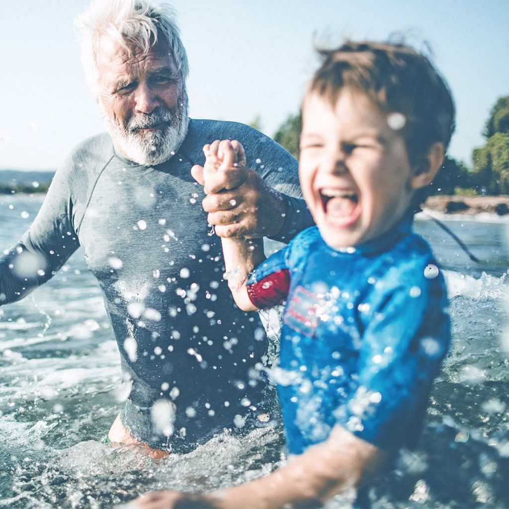 grandfather and grandson playing in the sea