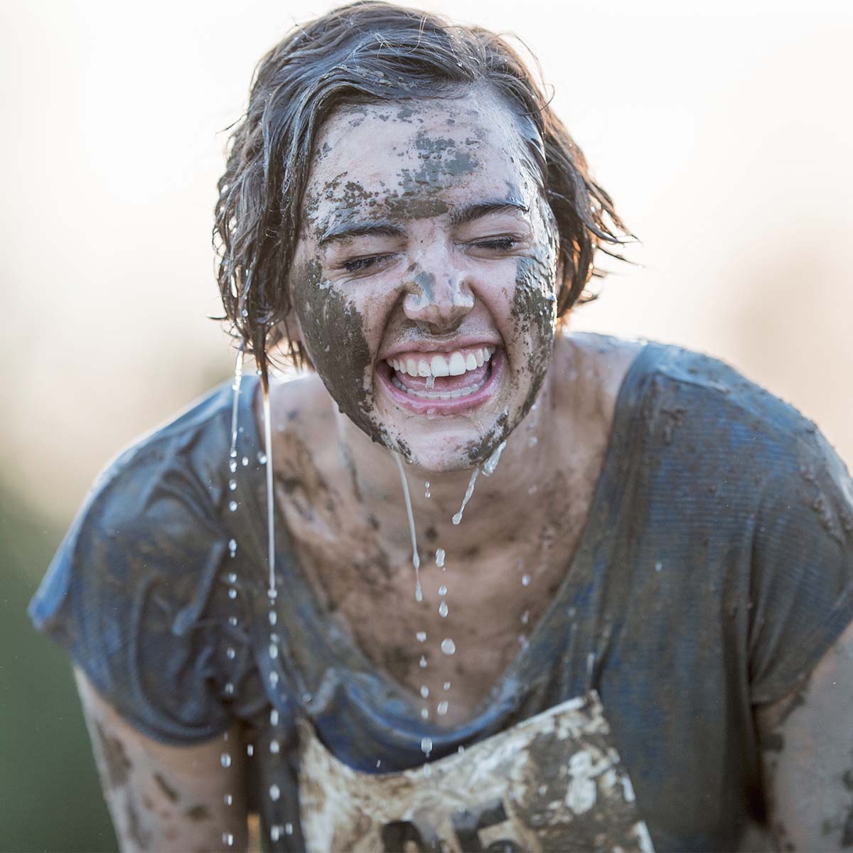 woman laughing covered in mud